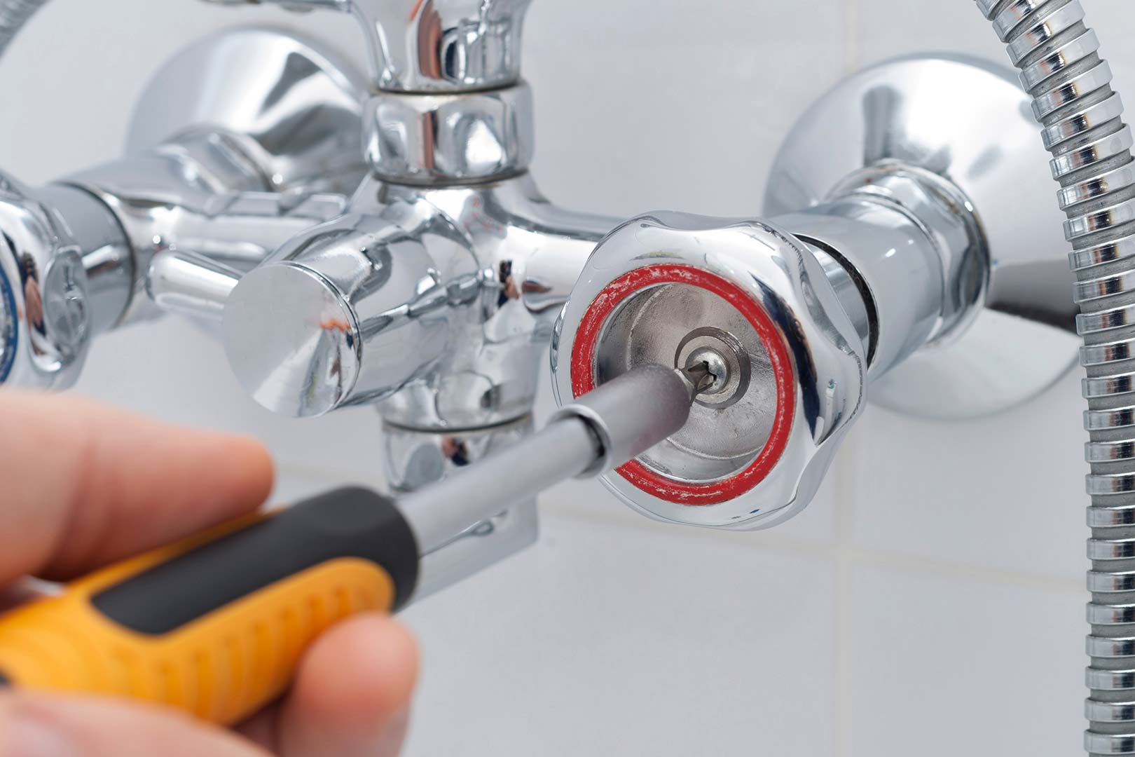 hand using screwdriver on tub faucet ontario ca