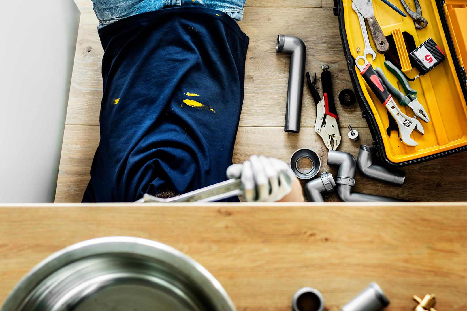 plumber lying on floor with head under sink ontario ca