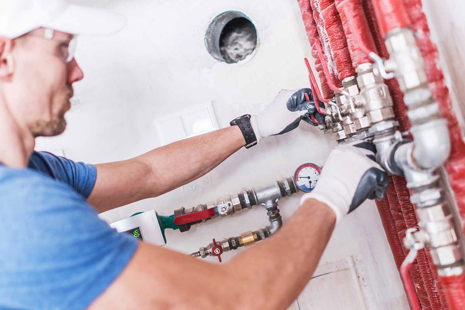 plumber working on red industrial pipes ontario ca